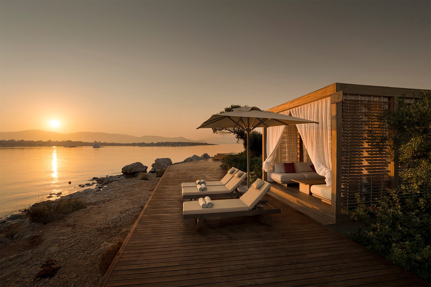 Beach cabana and loungers on the deck at sunset